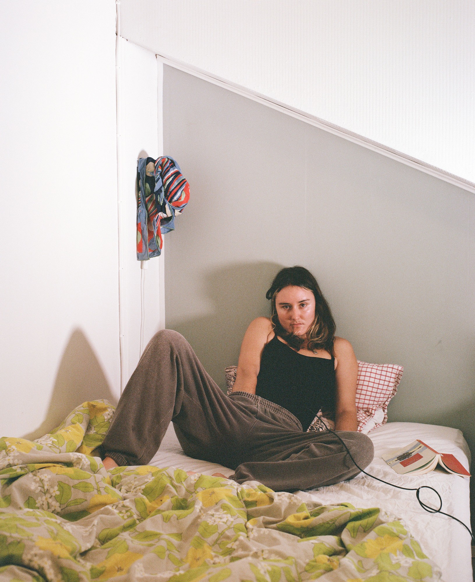 Portrait seated on a bed in the residency studio