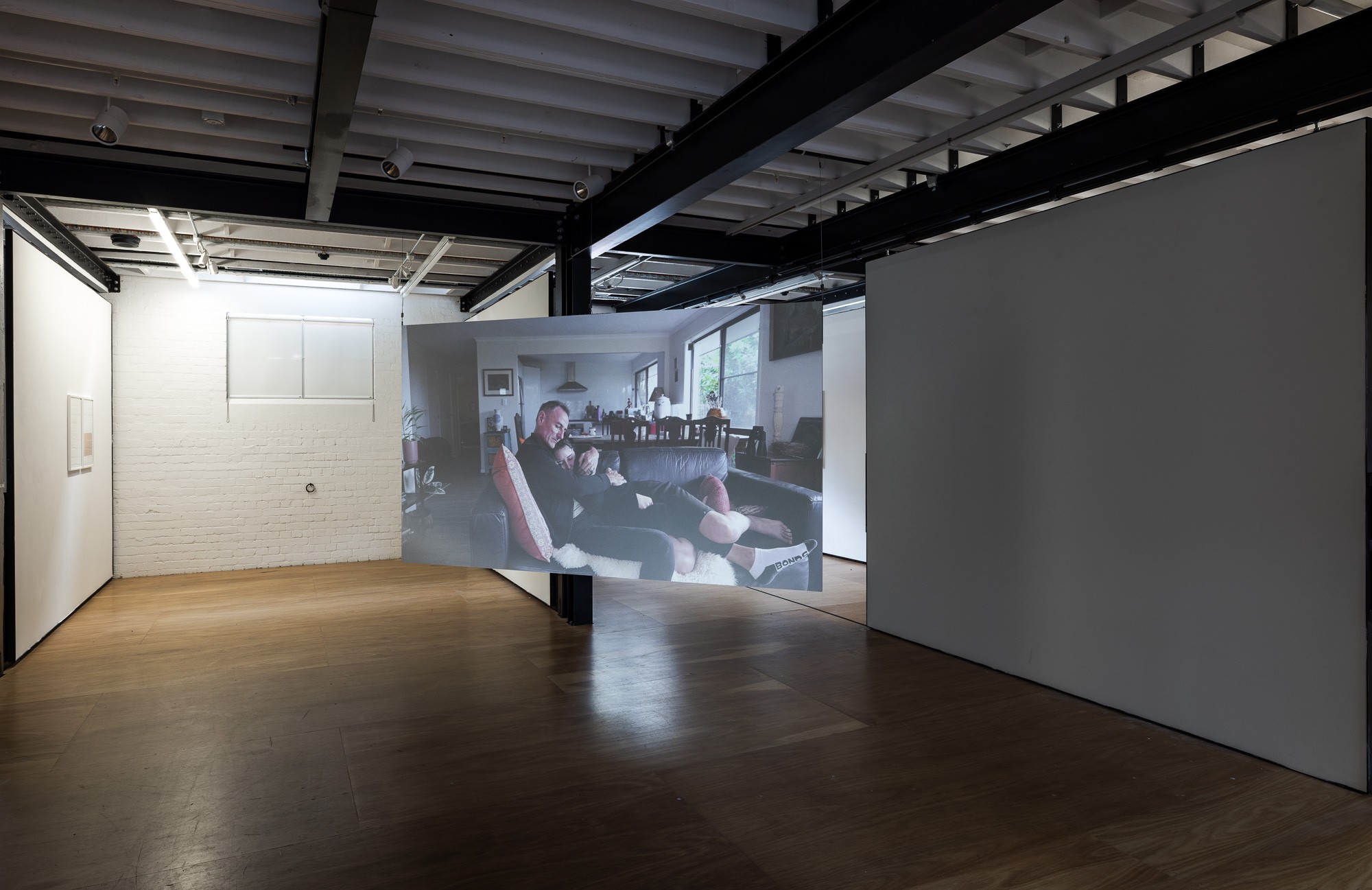 Auto Sun installation, projected video of two figures embracing on a couch