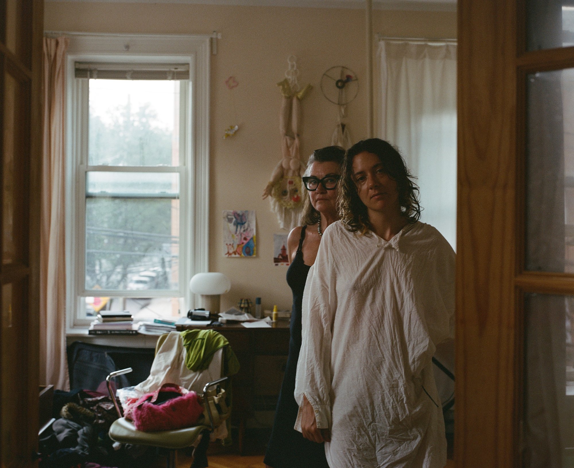 Two women standing together in a bedroom doorway