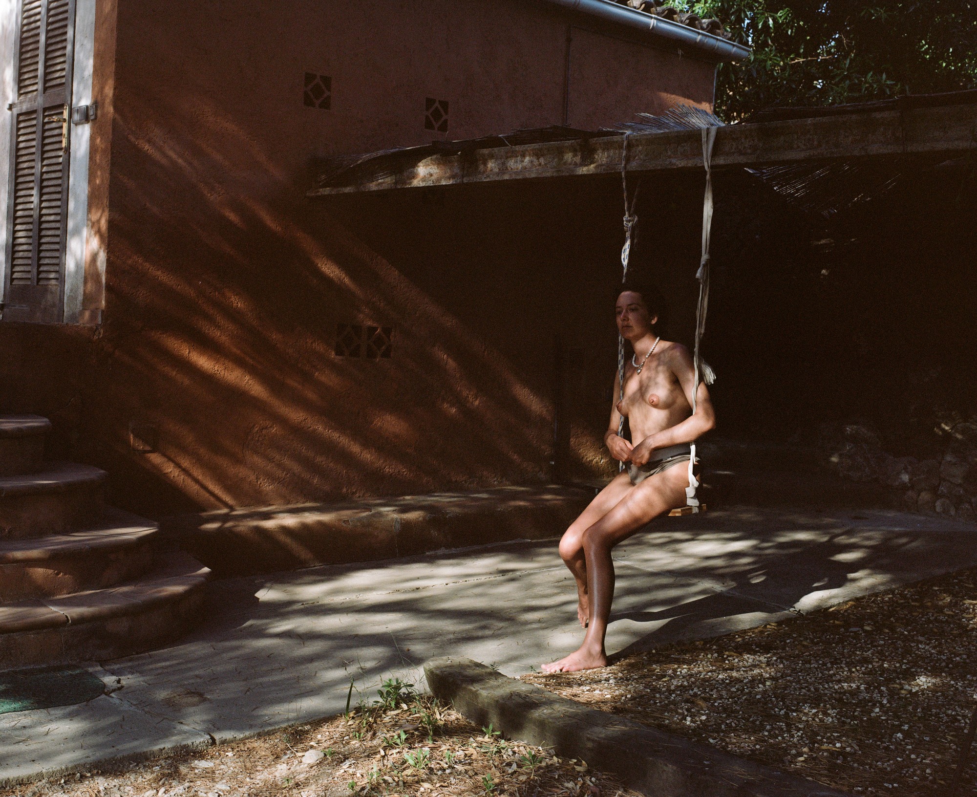 Portrait on a rope swing in dappled light