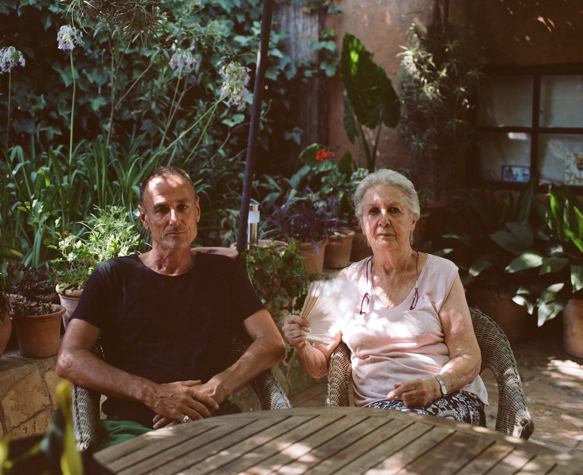 Portrait of an older man and woman seated in a garden