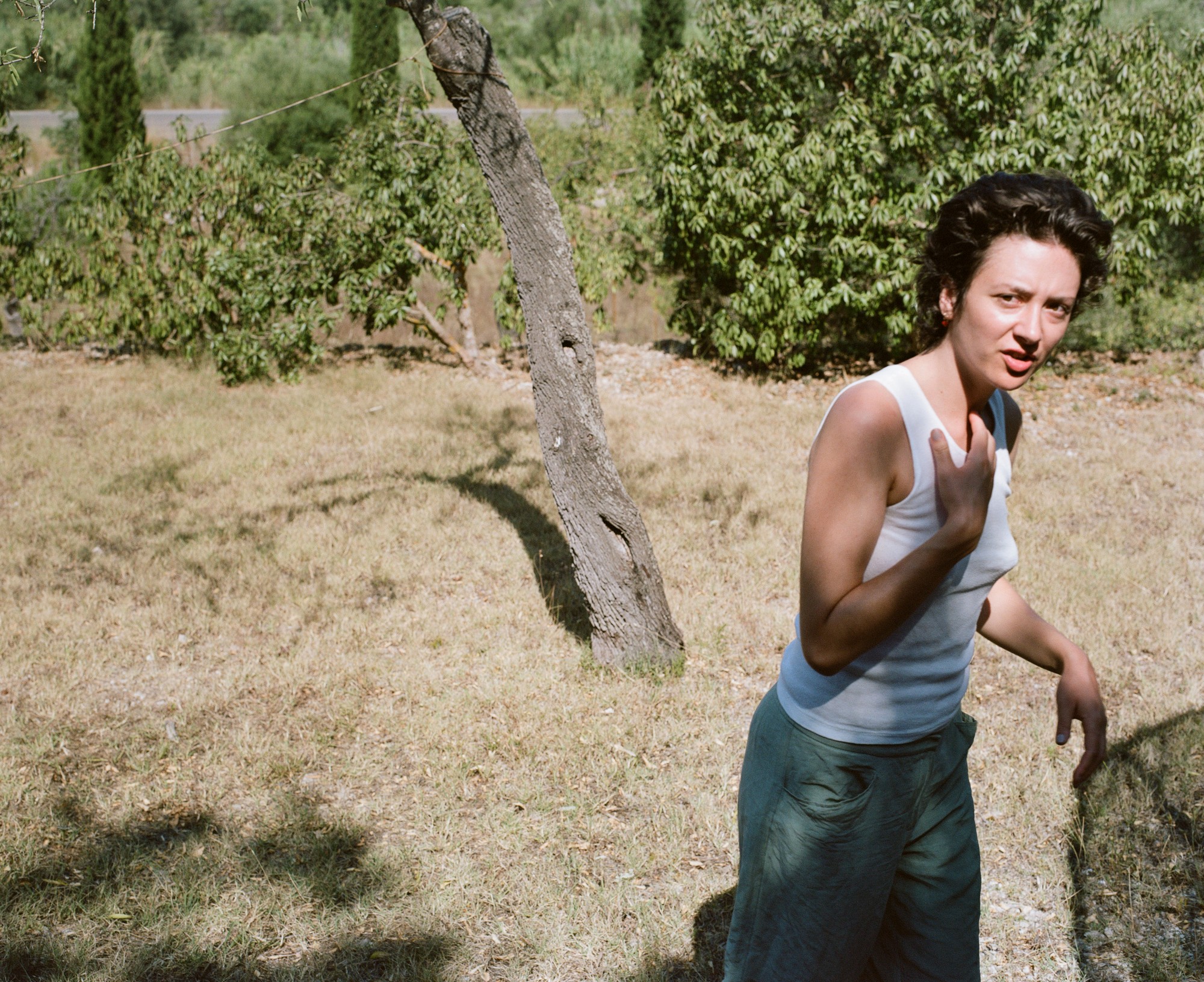 Candid portrait outdoors, hand raised to chest