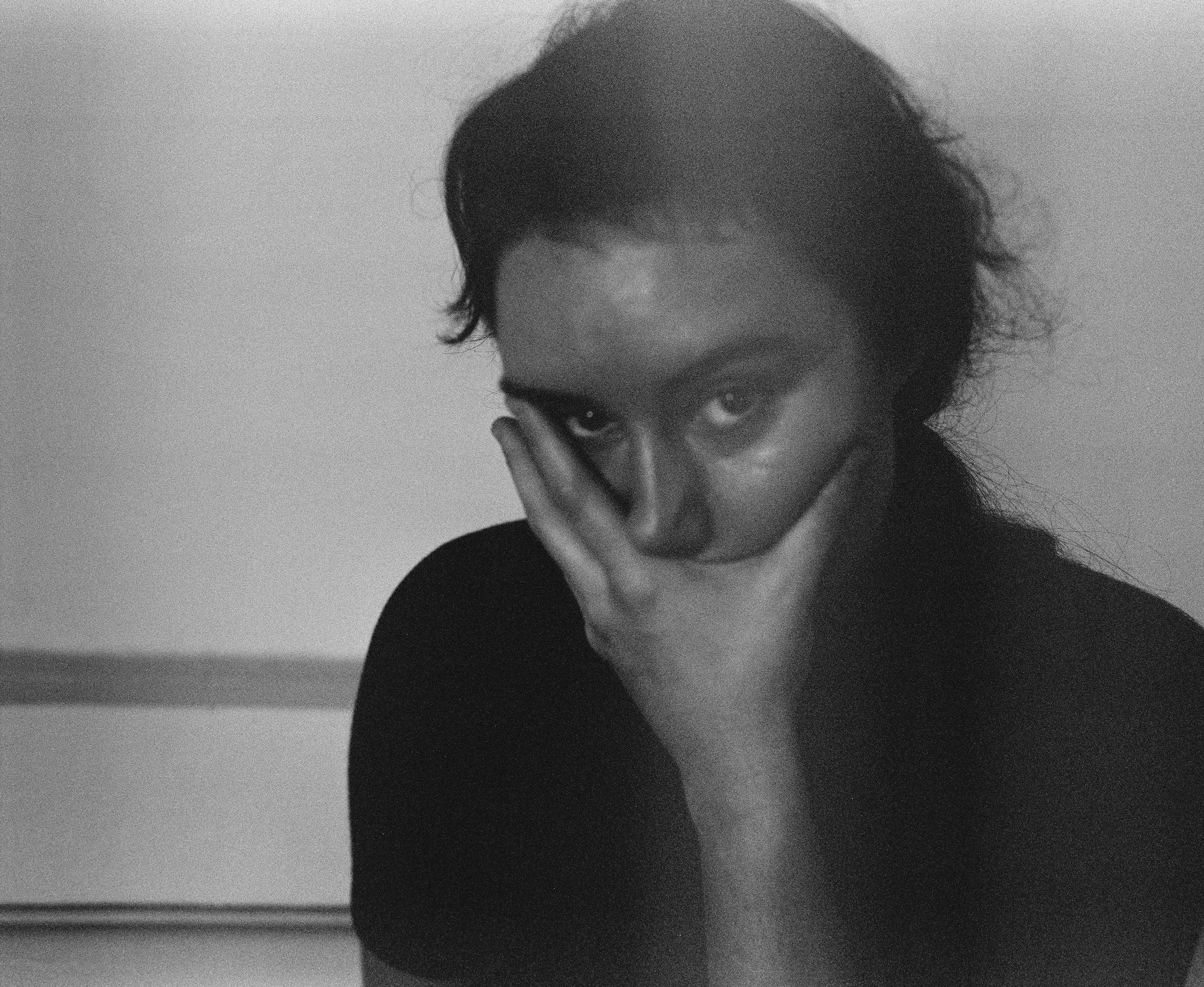Close-up black and white portrait, hand across the face