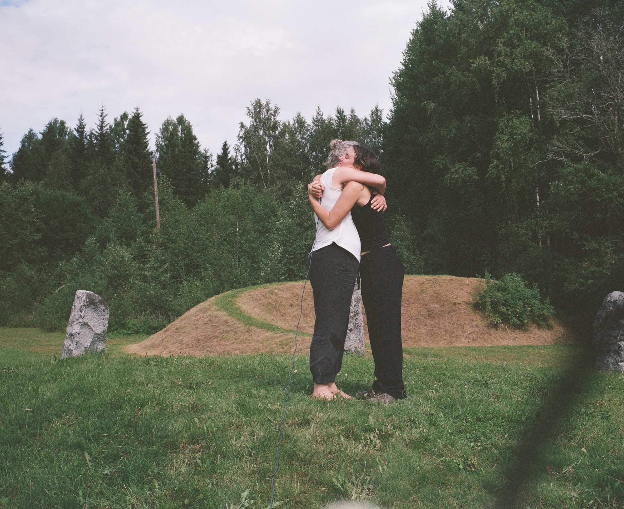 Two figures kissing among standing stones