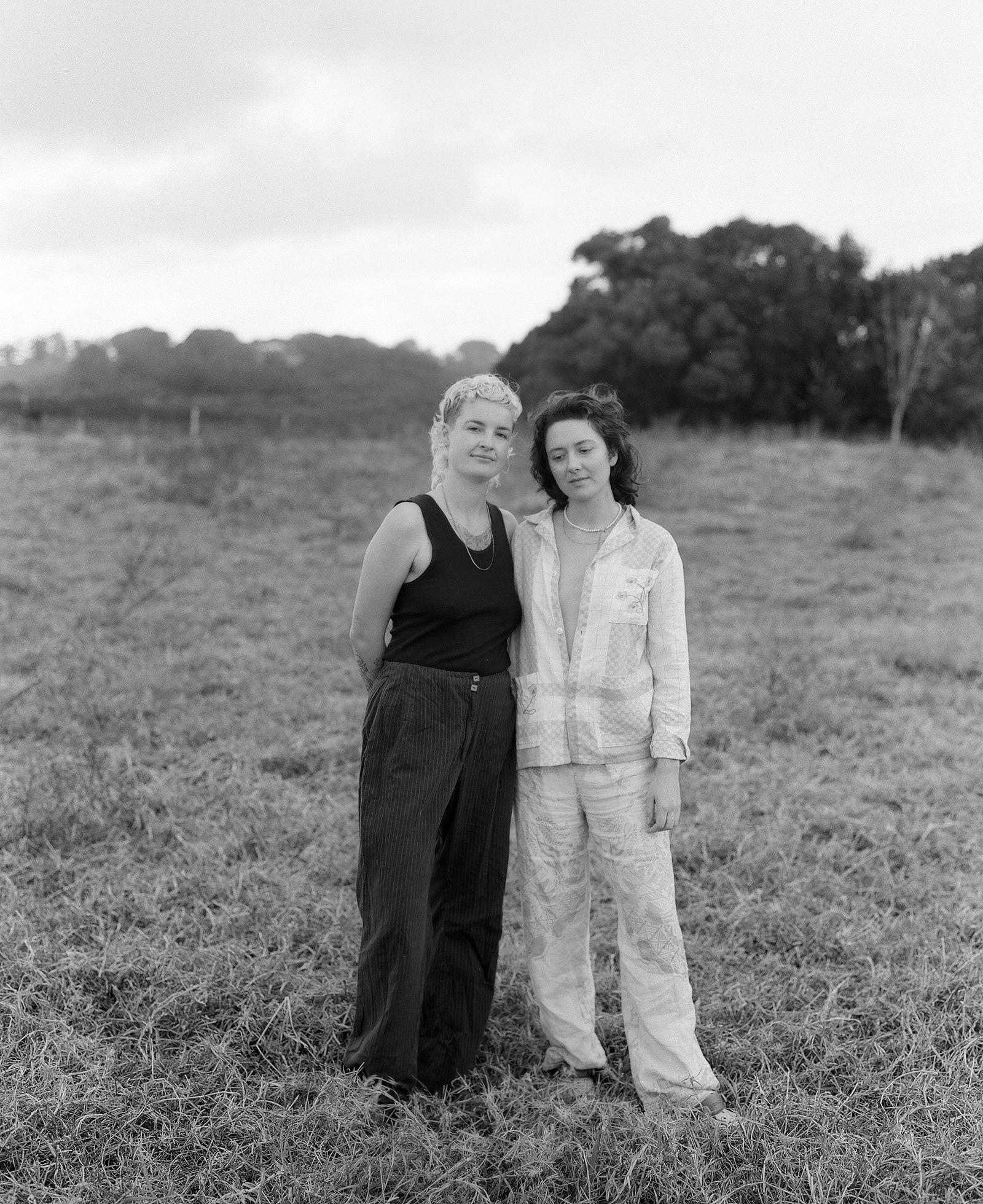 Portrait of two women standing close together in a field